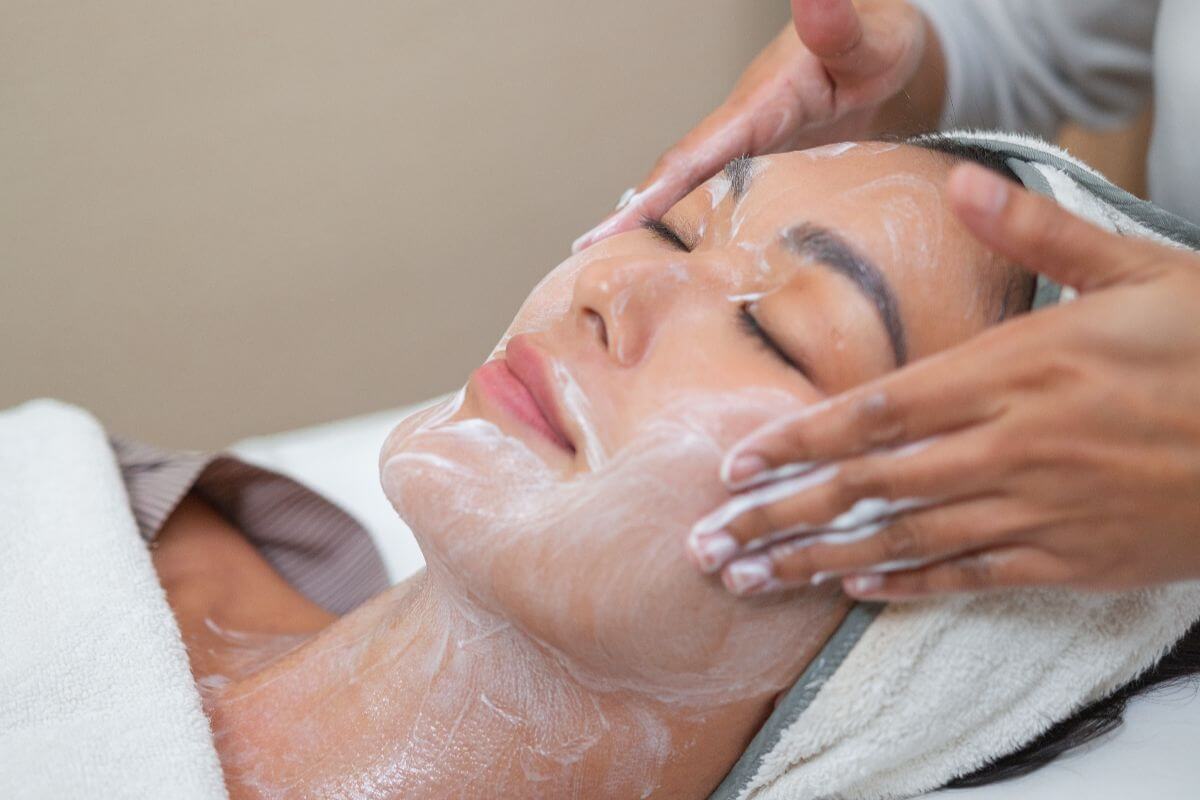 Woman receiving a professional facial care preparation treatment prior to laser rejuvenation, ensuring the skin is cleansed, soothed, and optimally prepared for the procedure.